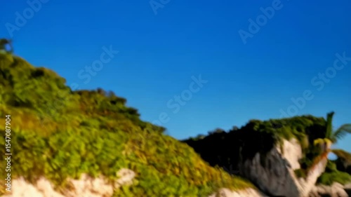 Tube container of sunscreen product on sand beach coastline background with clear blue sky and water