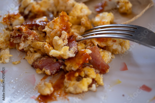 acercamiento de tenedor con huevo con tocino