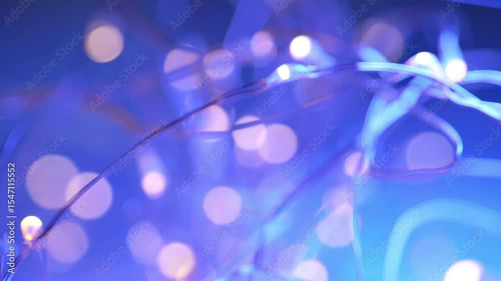 Garlands in a soft lilac and blue light.New Year and Christmas Festive Wallpaper.Garland light on blue background