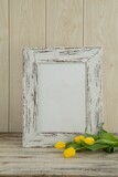 Photo frame and flowers on table