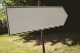 Front view of blank direction sign pointing to the right against forest