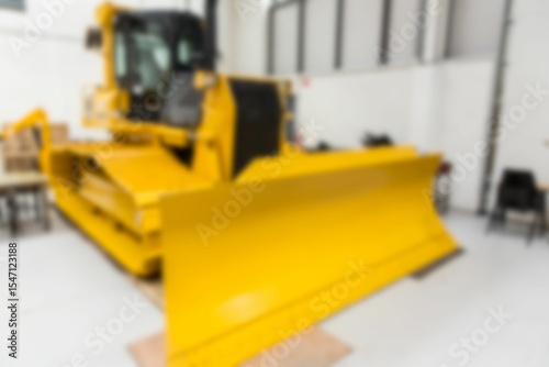 Flat design is showing large yellow bulldozer sitting in warehouse with chairs and crates