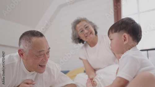 Grandparents spend quality time with their grandchild in a cozy bedroom setting