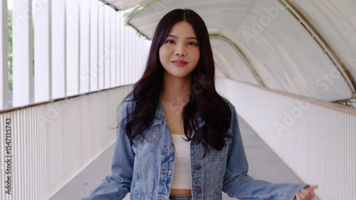 Portrait of Asian woman shopping goods outdoor in market. Attractive young girl holding shopping colors bags then look at camera while walk with happiness enjoy purchasing in shopping mall center.