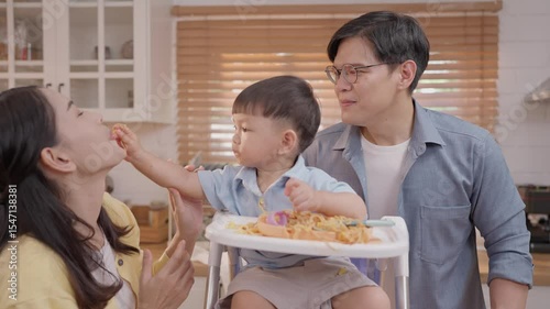 Family fun during snack time in a modern kitchen with playful toddler's antics