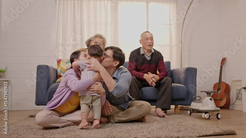 Family gathering brings joy as toddler runs to grandparents in cozy living room