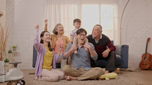 Family gathers in living room to celebrate special occasion filled with joy and laughter