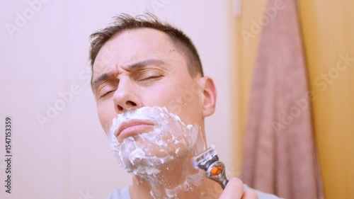 Man shaving his beard in the bathroom