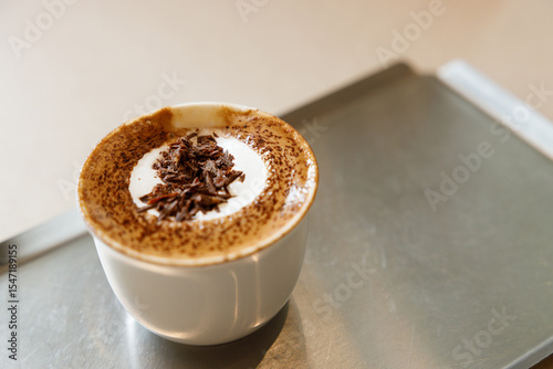 Cup of hot milk chocolate mocha coffee on table by the window.