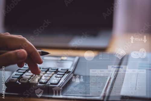 A person using a calculator with virtual financial icons, representing business planning, budgeting, accounting, and financial analysis in a modern digital workspace.