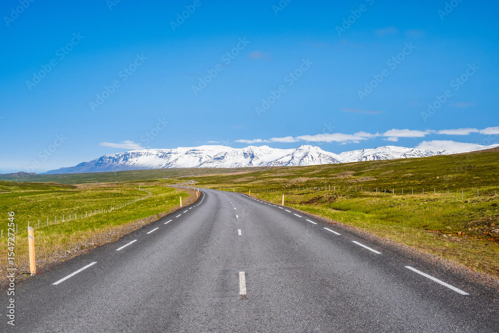 Fototapeta premium Road and snow covered mountains in North East Iceland 