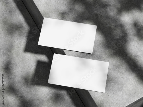 Business card mockup on neutral concrete surface with shadow detail.