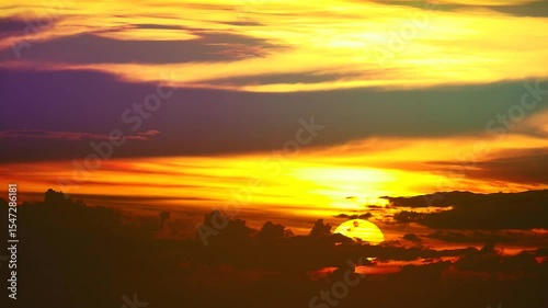 mesmerizing beauty of a sunset where the interplay of warm and dark colors creates a visually stunning scene. It is a vibrant evening sky scene time lapse