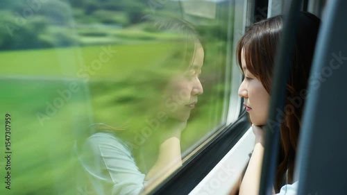 Footage of young woman looking thoughtfully out of a moving train window. Capturing a moment of contemplation, travel, and introspection. Scene of a solo journey.