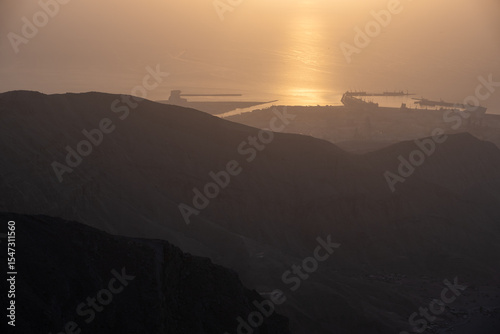 sunset in the mountains with sea view, horizon, reflection of sun in sea at sunset, golden hour 