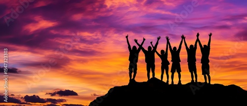 Group of friends celebrating sunset on a mountain top, raising hands together, enjoying nature and adventure in silhouette against vibrant sky.