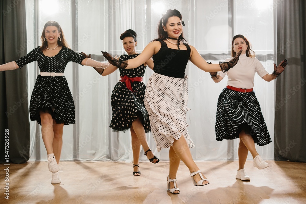 Naklejka premium Four pinup dancers wearing polka dots swinging in formation