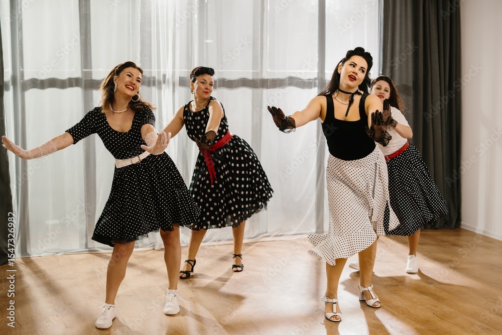 Naklejka premium Four pinup women dancing a choreography in a 1950s style