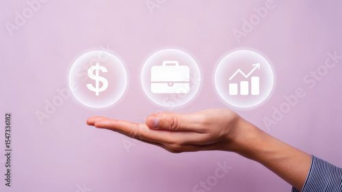 A hand holds icons representing finance, business, and growth against a pink background, symbolizing economic concepts.