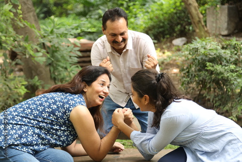 Slika na platnu Indian mother and daughter together Arm Wrestle at park