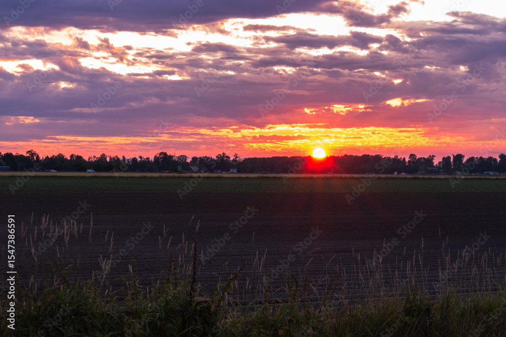 Obraz premium Sunset over farmers field