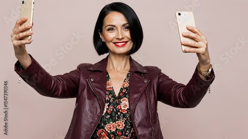 Woman takes selfie with two smartphones. Caucasian female capturing picture or video with dual mobile phones footage.