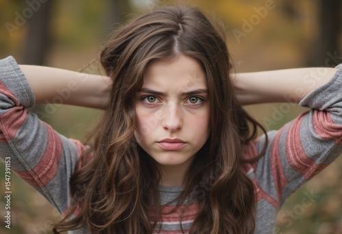 Teenage girl with pursed lips expressing mock annoyance in a natural setting