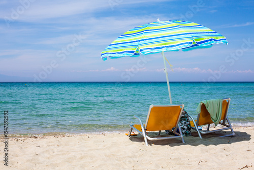 Fototapeta Naklejka Na Ścianę i Meble -  Background with chairs and colorful umbrella on sandy beach