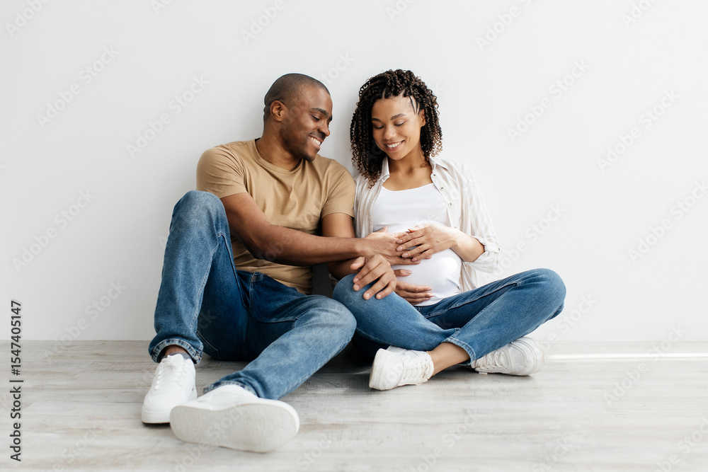 Young Black couple embraces lovingly, smiling husband touching womans pregnant belly. African American spouses experiencing emotional moment of connection, support, and shared joy in a bright home Young Black couple embraces lovingly, smiling husband touching womans pregnant belly. African American spouses experiencing emotional moment of connection, support, and shared joy in a bright home