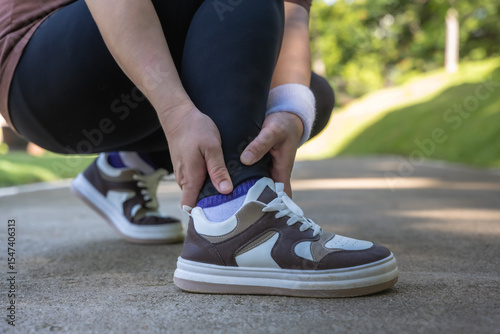 Konstfotografi Close up sportswoman feeling ankle pain during exercise in park