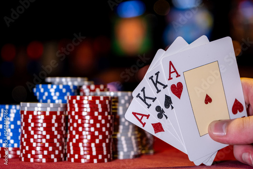 Close-up cards for playing poker on a gaming table in a casino against a background of chips. Background for a gaming business. Holding playing cards, playing poker at green table.