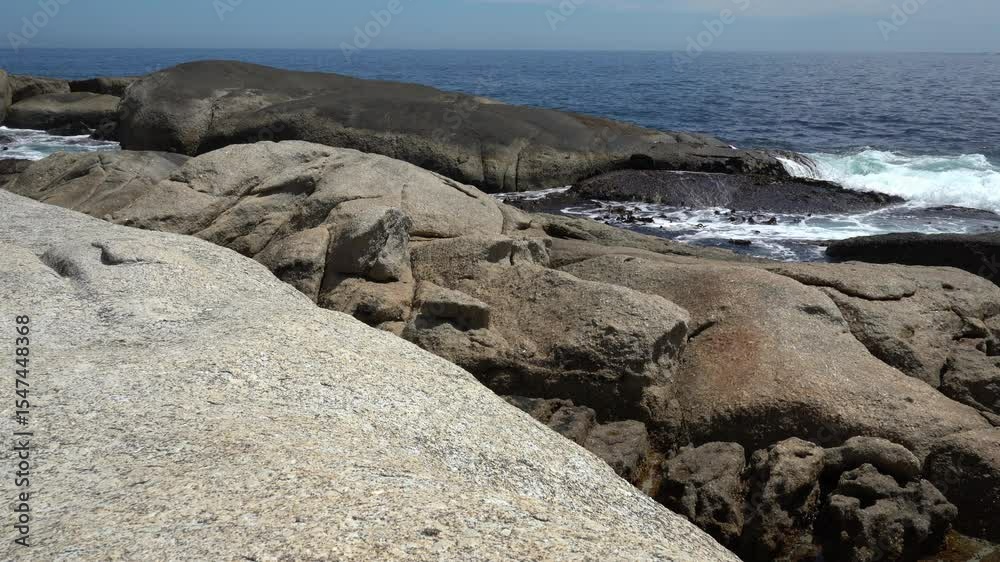 Waves crashing over the boulders along the rocky shoreline Waves crashing over the boulders along the rocky shoreline