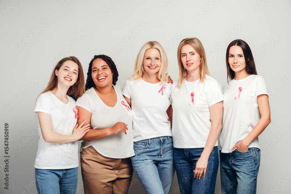 Obraz premium Diverse women wearing pink ribbons are embracing for breast cancer awareness