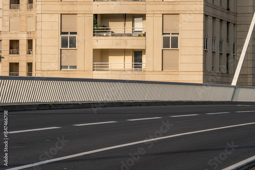Modern empty street with geometric lines and shadows under warm sunlight, ideal for copy space or background usage in contemporary urban design and mobility concepts.