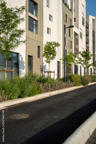 Contemporary sidewalk and residential buildings with warm sunlight and lush greenery, designed for themes like urban growth, sustainability and architectural detail.
