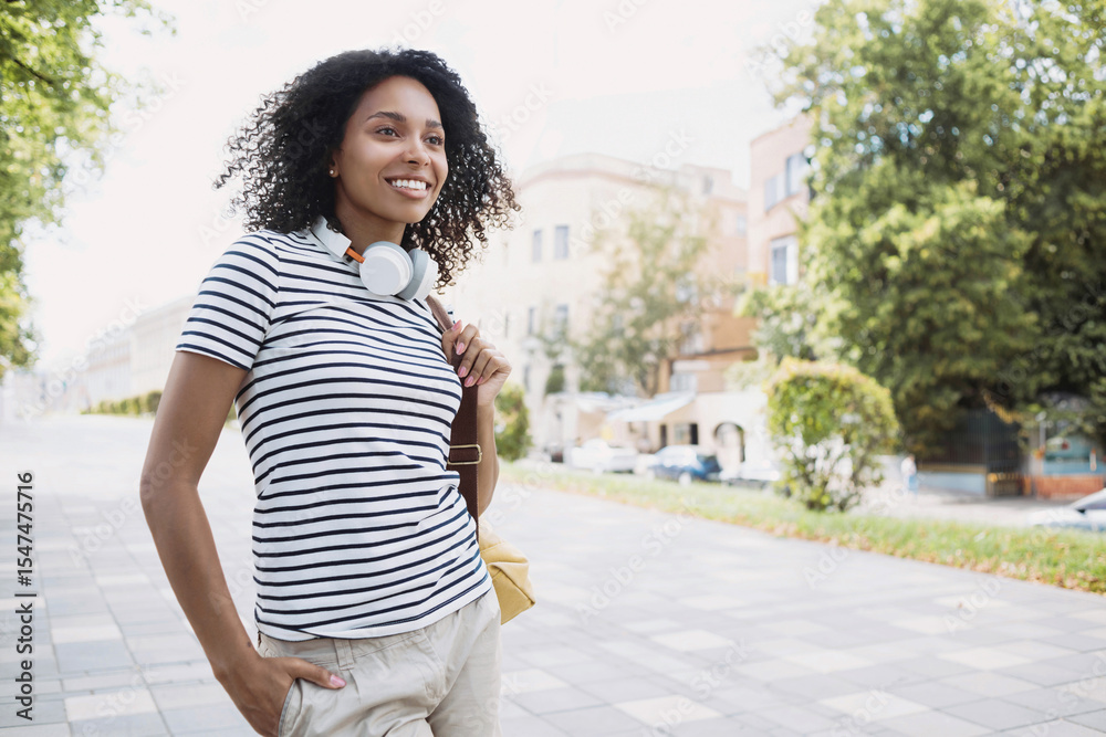 Fototapeta premium Young beautiful woman summer portrait, Happy african american student girl smiling in a city, People enjoy life, student lifestyle, city life, travel concept