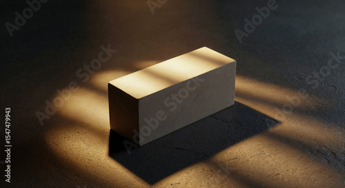A light beige, rectangular, block-like object sits centered on a dark gray stone surface. 