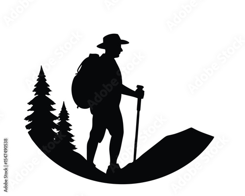 Silhouette of a hiker walking with a backpack and hiking stick near trees on a trail.
