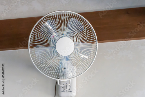 室内の壁に設置されたシンプルな扇風機