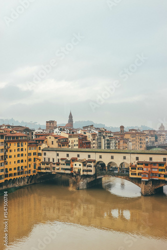 ponte vecchio florence italy with water reflections and cloudy sky