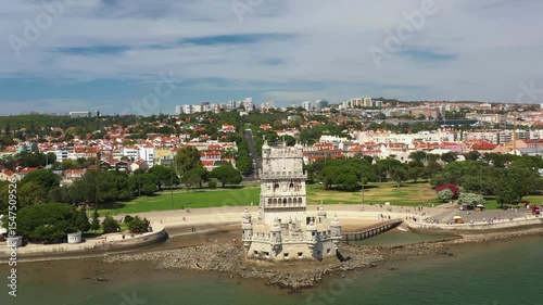 Aerial drone shot of Belem Tower on the Tagus River overlooking the cityscape in Lisbon, showcasing its historic architecture and scenic surroundings