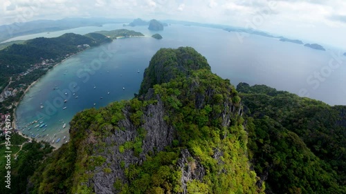 Wallpaper Mural Sweeping drone shot reveals the dramatic limestone ridge towering over Coron-Coron Beach and El Nido’s calm bay. Dozens of boats and distant islands complete this vast tropical panorama. Torontodigital.ca