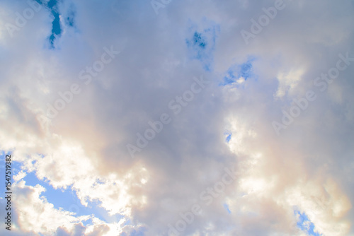 Blue sky with a pink stripe at the horizon. Calm background with evening clouds.