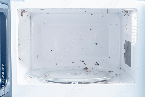 Microwave with traces of food. Dirty surface of the inside of the microwave.