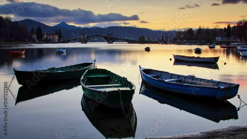 Peaceful boats rest on calm lake water mountains fade into twilight sky