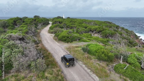 Drone Shot of 4WD Driving Toward Green Cape Lighthouse Along Remote Coastal Road