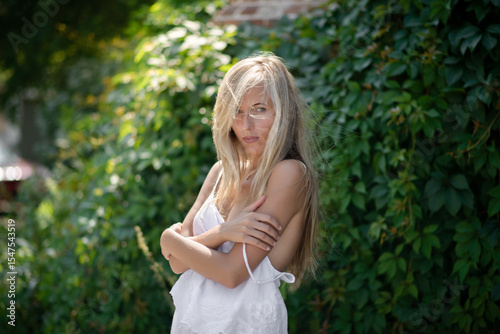 Outdoor portrait of beautiful young woman with green eyes at summertime.