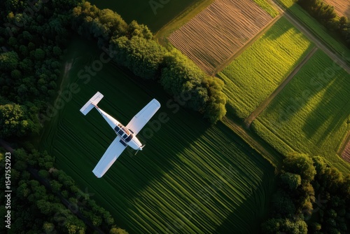 Small airplane flying over green agricultural fields during golden hour near rural area