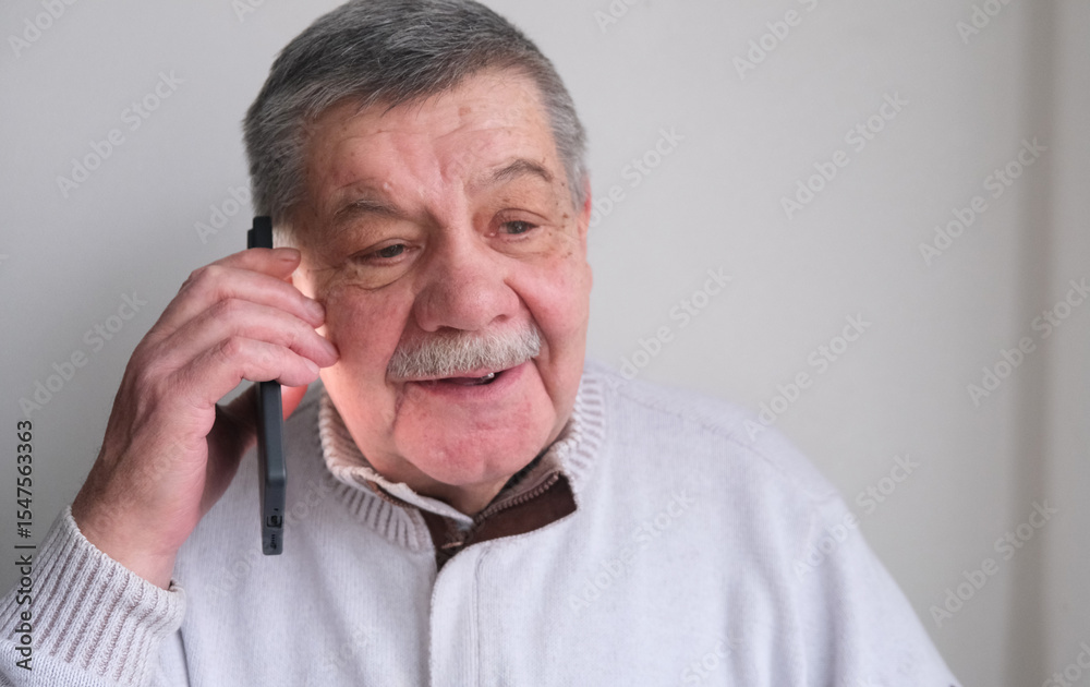 Fototapeta premium A phone call, laughter, and an elderly man in a house, living room, and a conversation with a contact and happy person. A house, communication, and an elderly man with a smile inviting, spending time 