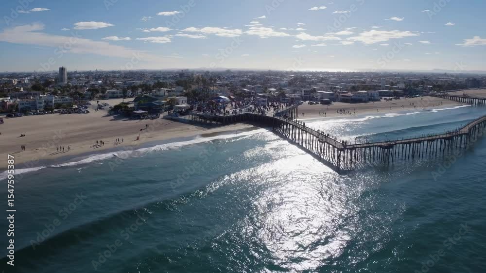 An aerial view of the ocean and pier. Pier with a sunny beach on the ocean. Scenic coastal town with a blue sky. A bird's-eye perspective of the sea and the pier lifestyle. An aerial view of the ocean and pier. Pier with a sunny beach on the ocean. Scenic coastal town with a blue sky. A bird's-eye perspective of the sea and the pier lifestyle.
